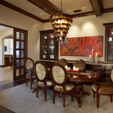Traditional Dining Room With Wood Details, Oval Dining Table, Velvet Cushioned Dining Chairs and Midcentury Modern Chandelier 