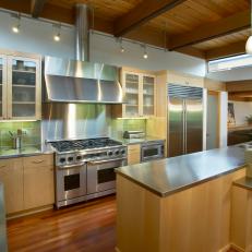 Green Tile Backsplash Surrounding Stainless Steel Range and Stove Over Stainless Steel Countertop in Midcentury Modern Kitchen 