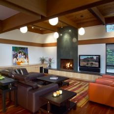 Midcentury Modern Living Room With Low Height Fixtures, Orange Leather Armchairs and Chocolate Brown Leather Sectional 