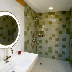 Midcentury Modern Bathroom With Open Walk In Green Tile Shower, Circular Lit Mirror and White Sink 