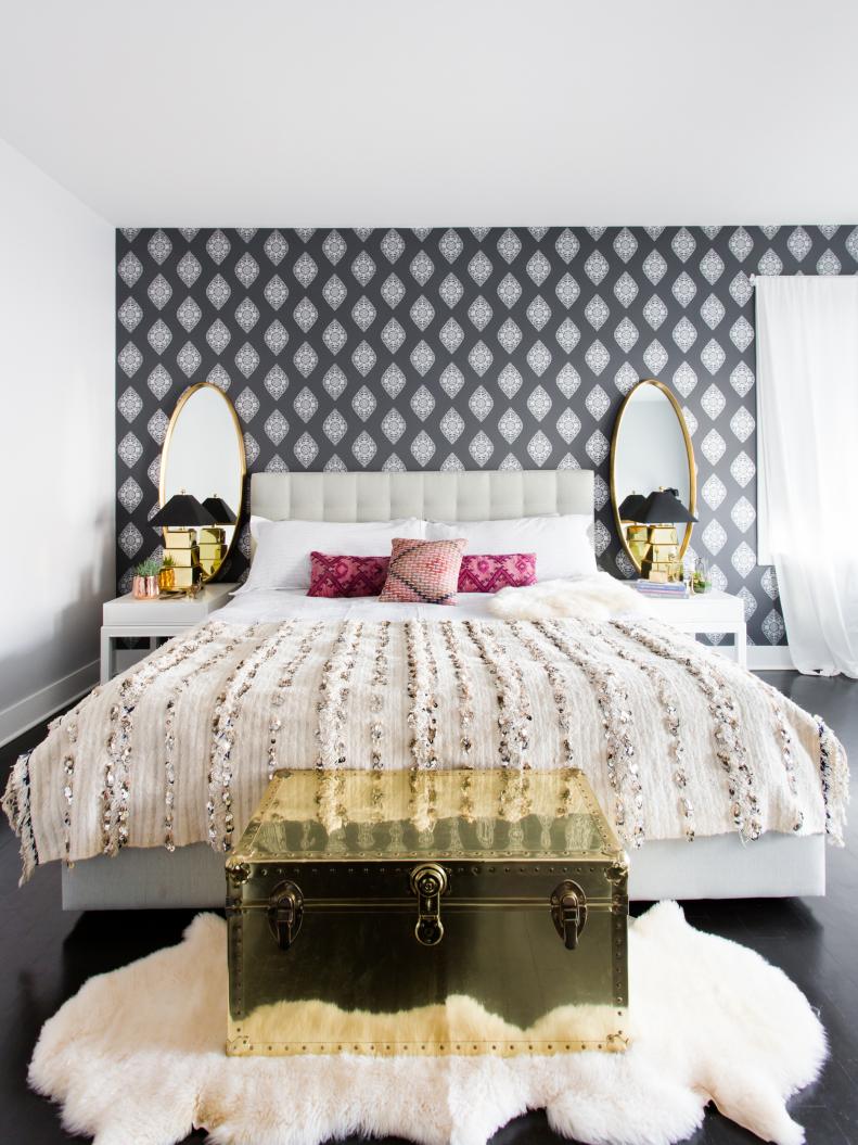 Bedroom With Brass Chest and Gray and White Wallpaper Accent Wall