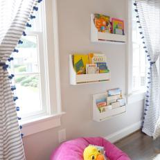 Kids' Reading Nook With Face Out Bookshelves and Pink Bean Bag Chair