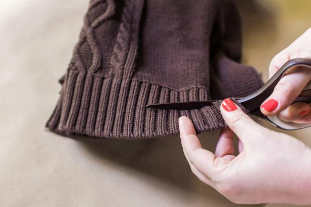 Step 5- Cut SweaterFirst, using scissors, cut 1-inch off the sweater’s bottom edge.  Next, cut ½- inch “fringe” into the sweater material, using the knit pattern as your guide. HINT: Cut the waist band in half so you’ve got one long piece of material to work with.