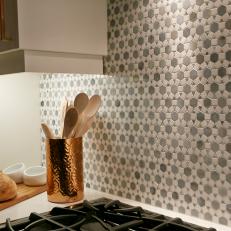 Decorative Hexagonal Pattern Tile Backsplash Over White Countertop and Black Stovetop 