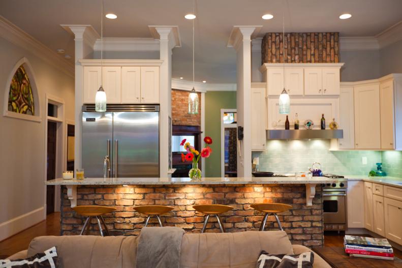 Rustic Craftsman Kitchen with Brick Island, White Cabinets and Pendant Lights