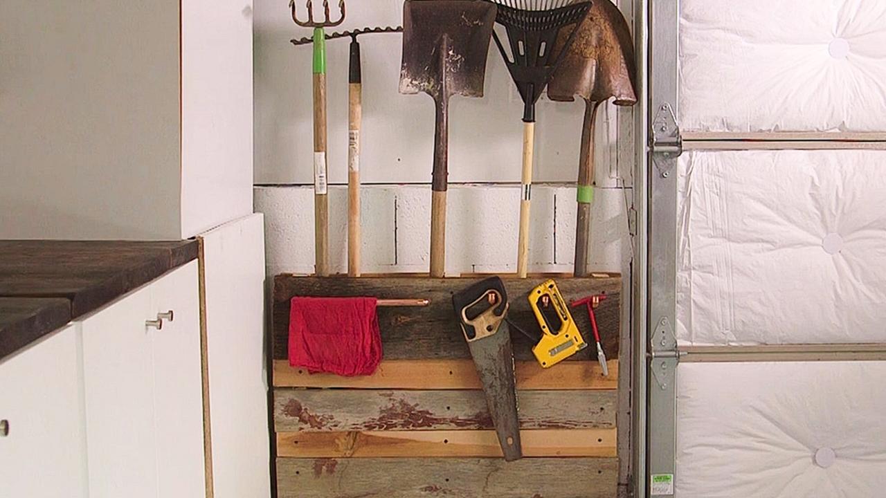 Made a garden tool rack from hooks and an old piece of lumber