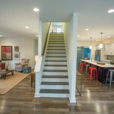 Open Concept Living Area With Center Staircase and Colorful Accents