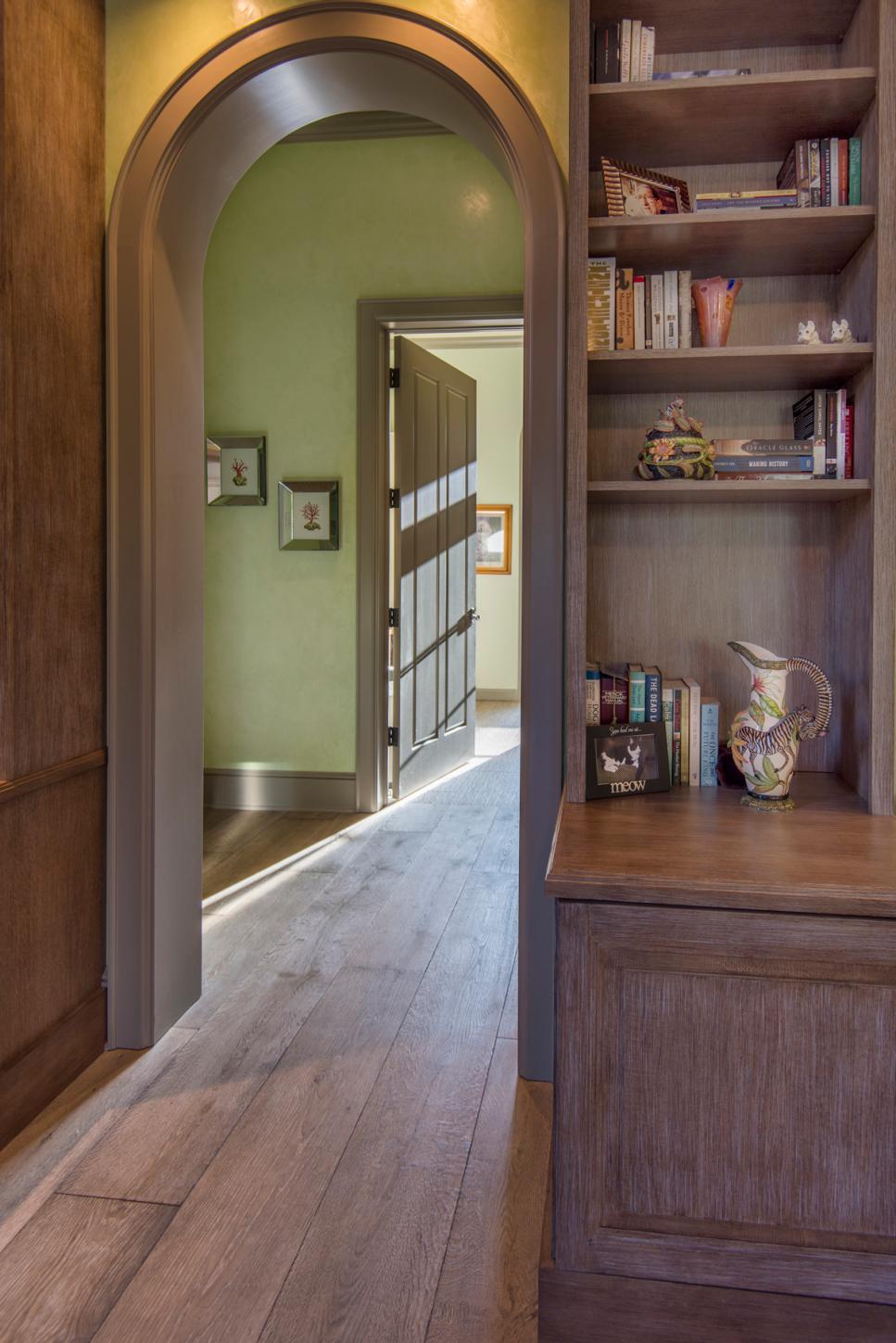 Arch Doorway Over Hardwood Hall With Built In Wood Bookshelf for