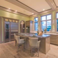 Spacious Transitional Kitchen With Yellow-Green Walls, Eat in Island With Individual Place Lights and Stainless Steel Refrigerator