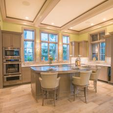 Transitional Kitchen With a Pop of Yellow Walls Around a Neutral Tray Ceiling and Eat In Bar With Leather Chairs 