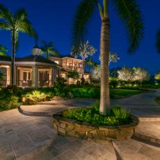 Palm Trees and Lush Grasses Surrounding Stone Tile Walkway In Backyard Tropical Landscaping 