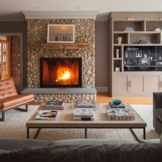 Fireplace Covered in Riverbed Stones Creates Focal Point in Contemporary Living Room