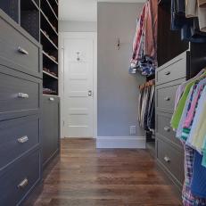 Gray Walk-In Closet With Hardwood Floor