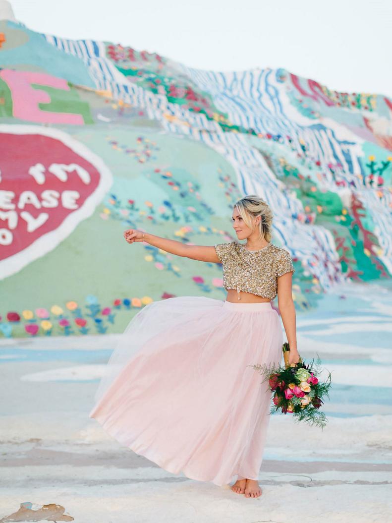Bride in DIY Wedding Gown Poses With Pink and Green Bouquet for Southwestern Wedding. 