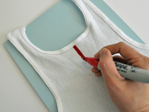 Place paper inside shirt to avoid marker bleeding onto other side. Draw stripes on tank top with permanent marker or fabric marker. Use ribs of shirt as a guide and pull marker along fabric rather than pushing it.