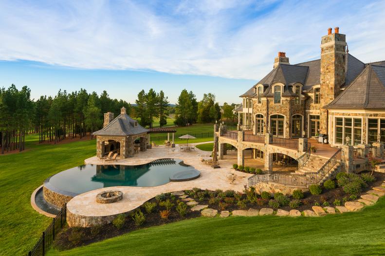 Traditional Exterior With Neutral Stone Patio and Infinity Pool