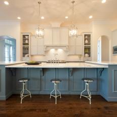 Blue and White Open Plan Kitchen With Metal Stools