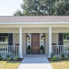 Inviting Country Front Entrance With Covered Porch, Natural Wood Door and Concrete Walkway 