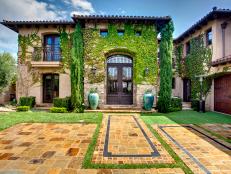 Mediterranean Exterior With Ivy, Evergreens and Paver Driveway