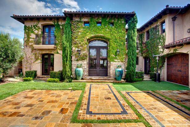 Mediterranean Exterior With Ivy, Evergreens and Paver Driveway