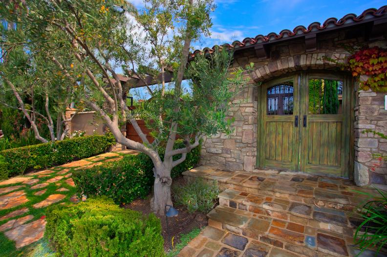 Mediterranean Exterior With Stone Walkway and Wooden Gates