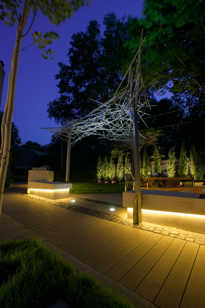 Modern Backyard at Night With Cove Lighting and Shade Structure
