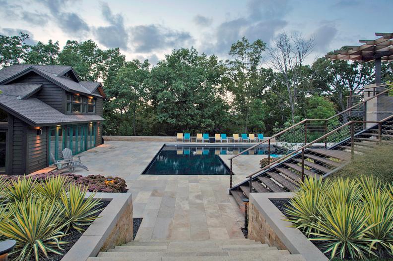 Contemporary L-Shaped Swimming Pool With Stone Patio