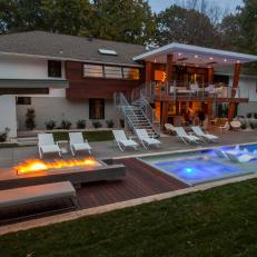 Midcentury Backyard at Night Features Pool and Fire Pit