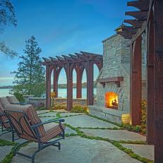 Stone Outdoor Fireplace Flanked by Rustic Pergolas