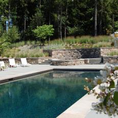Concrete Swimming Pool Patio With Elevated Hot Tub and Planted Hillside 