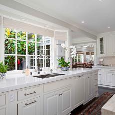Large Bay Window Over White Countertop and Cabinets in Bright Transitional Kitchen