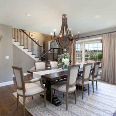 Traditional Dining Room With Farmhouse Influence Featuring Garden Tool Wall Art, Mounted Wooden Wine Rack and Chandelier