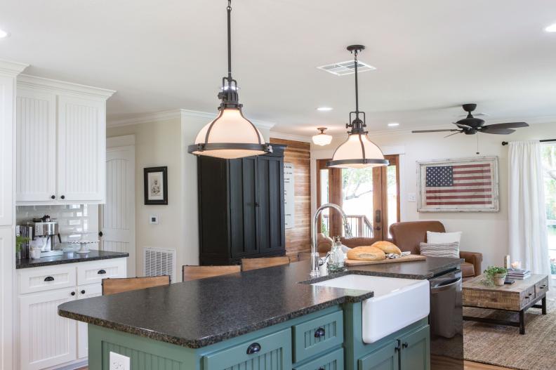 Large Kitchen Island with Black Countertop and Green Cabinets 