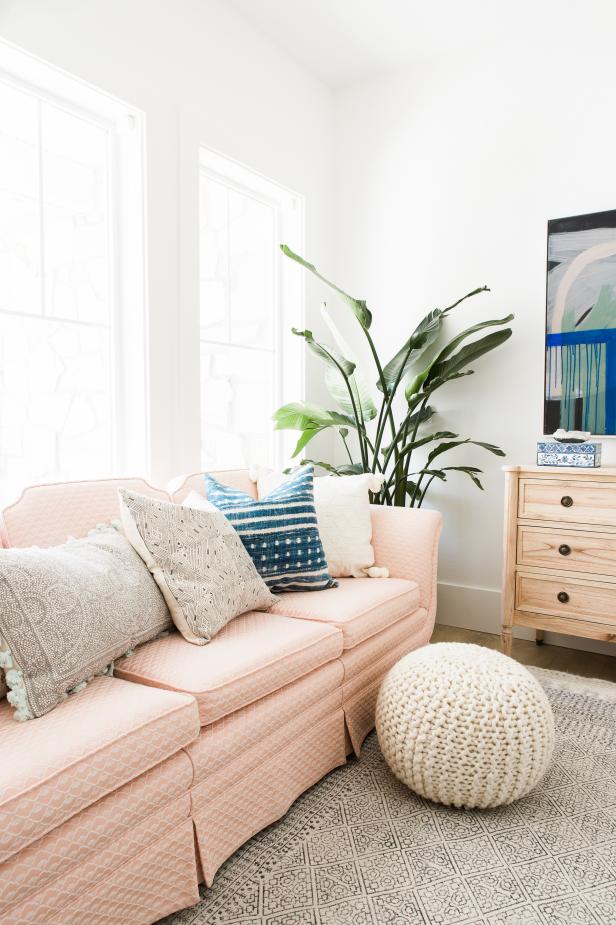 A glamorous living room with a pale, pink sofa anchors this space. 