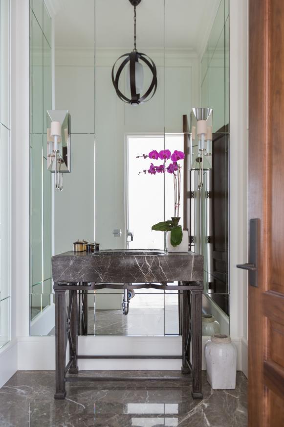 Marble Sink With Open Area Underneath in Front of Mirrored Backsplash