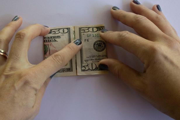 1 Dollar Bill Folded In Half With Black Background