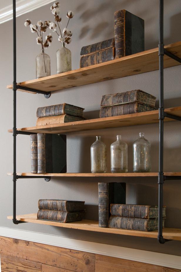 The Gaines installed a modern, sculptural  shelving unit in the Batson's living room, made from plumbing pipe and wood planks, as seen on HGTV's Fixer Upper.  (detail)