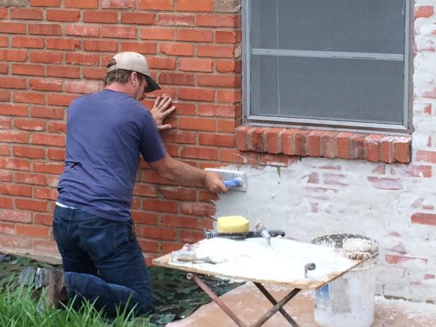 Chip uses a German Smear technique to partially cover the brick on the Jones's house, creating an elegant European look, as seen on Fixer Upper.