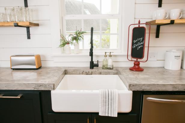 The kitchen in the newly renovated Magnolia House bed and breakfast features custom concrete countertops, a farm sink and stainless steel appliances, as seen on Fixer Upper. (after)