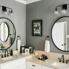 Gray and Black Bathroom With Round Mirrors