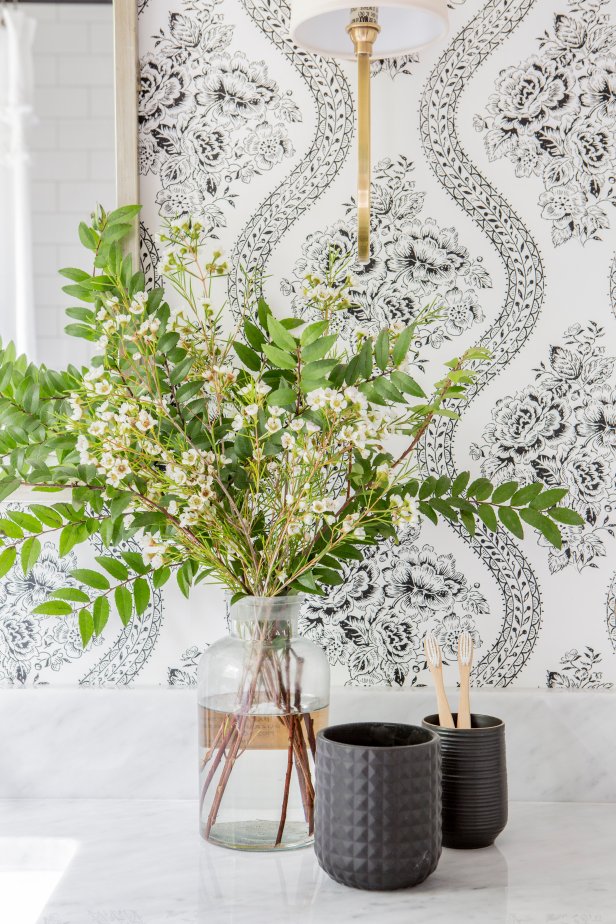 As seen on Fixer Upper, the Scivano's rennovated hall bathroom has new wallpaper and hardware. (After)