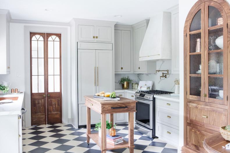Neutral Kitchen with Brown Wooden Island and Black and White Floors 