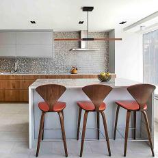Modern Gray and Orange Kitchen With Wood Barstools