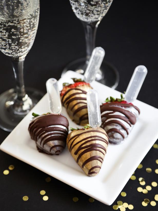 Toast your New Year’s Eve party guests with strawberries and champagne! Each berry is dipped in dark chocolate and then brushed with food-safe metallic luster dust. Luster dust is available for purchase at cake decorating supply stores.  Pipettes deliver a sip of bubbly champagne, so give it a squeeze as you take a bite of the strawberries. Pipettes are sold online and at many specialty kitchen stores.