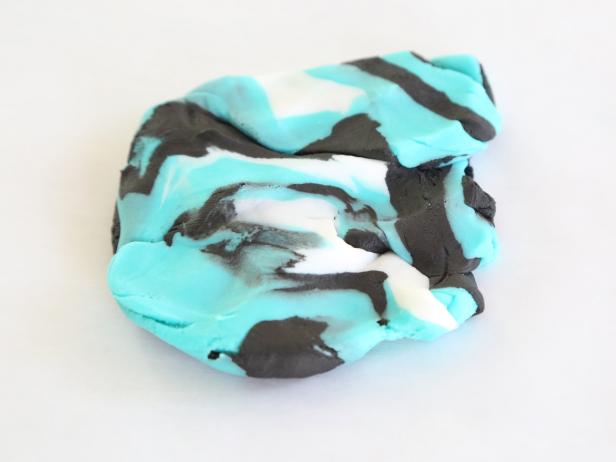 Choose three contrasting colors, such as black, white and teal, and lightly knead the three colors together. Don’t knead them too much or the colors will become muddy.