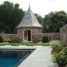 Swimming Pool and Cottage Storage Shed With Natural Rock Wall and Decorative Grass Checked Floor 