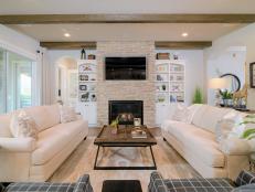 Living Room With Stone-Surround Fireplace and Exposed Ceiling Beams