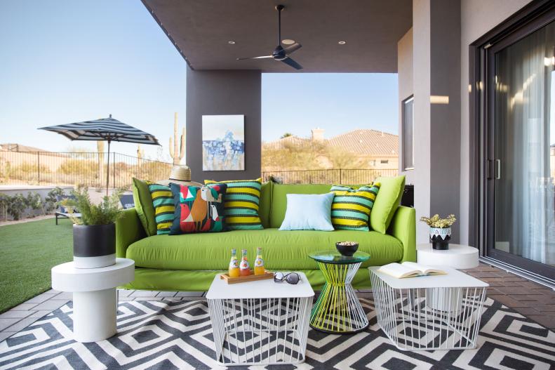 Lime green sofa over black-and-white geometric rug on covered patio