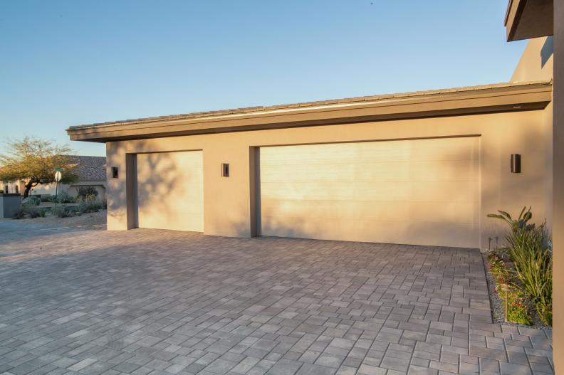 A stone paver driveway leads up to the home's three-car garage