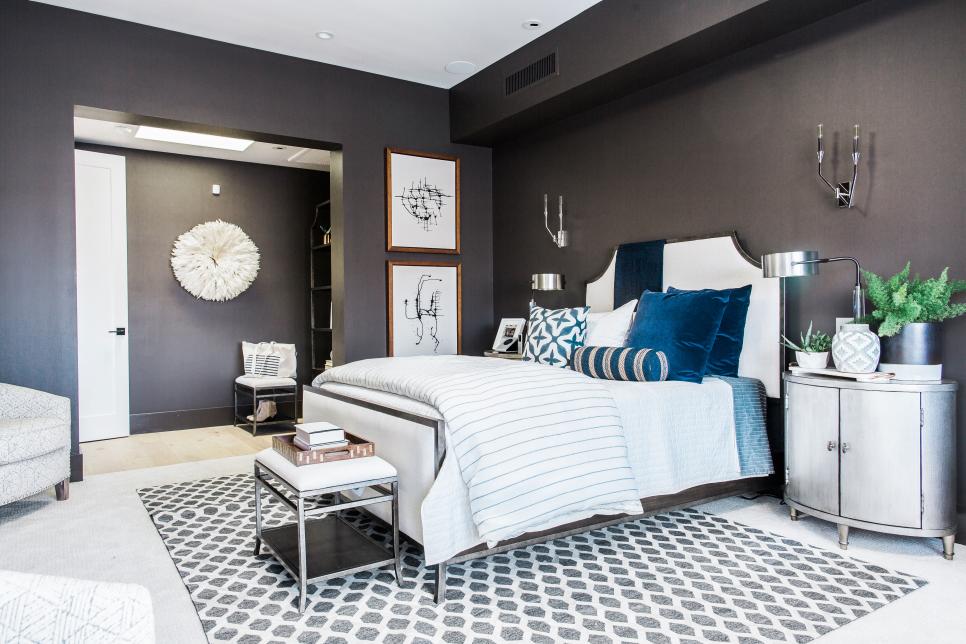 Master bedroom has charcoal walls, high-tech bed, oval nightstands
